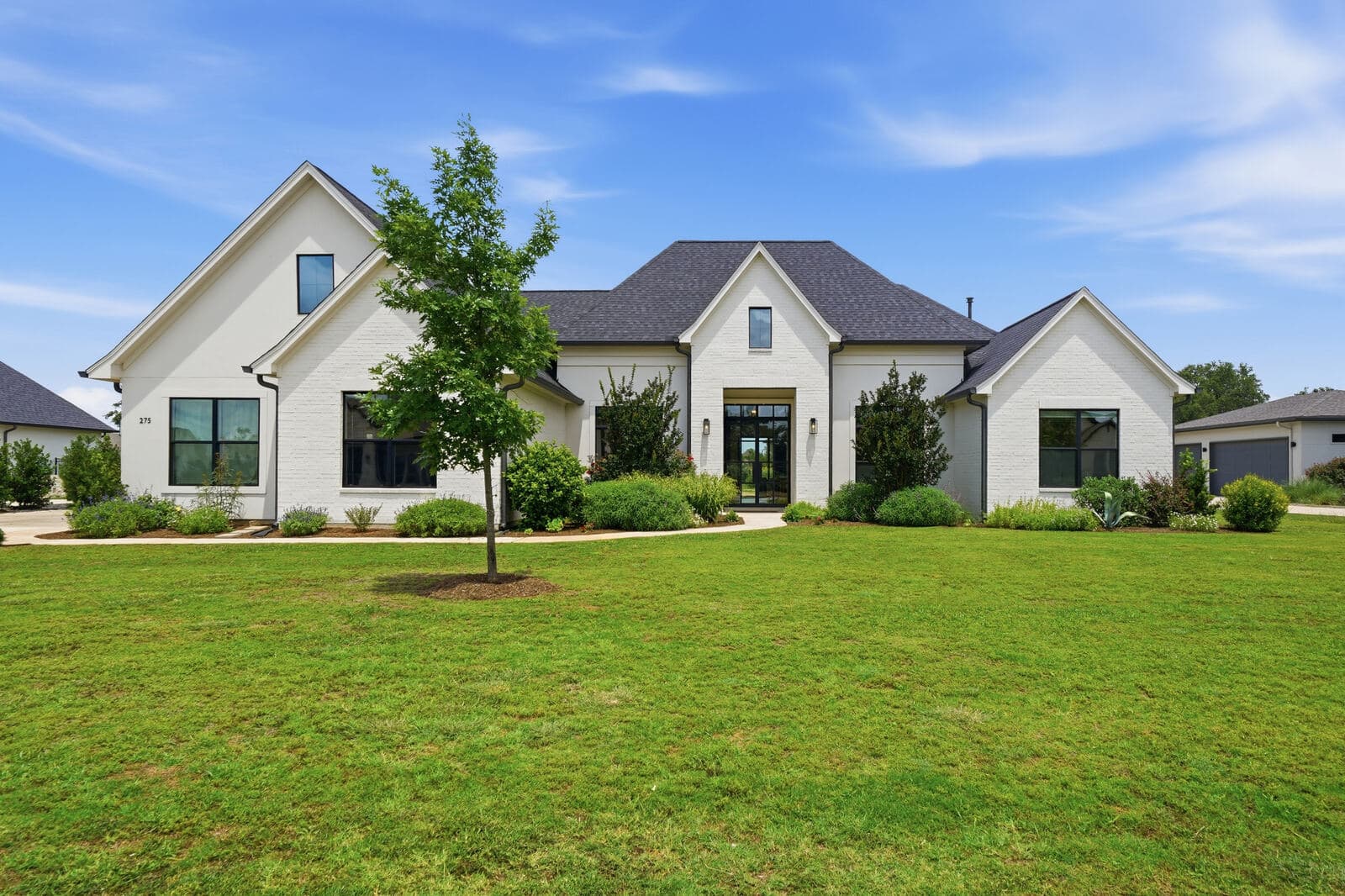 White brick home with a green front lawn